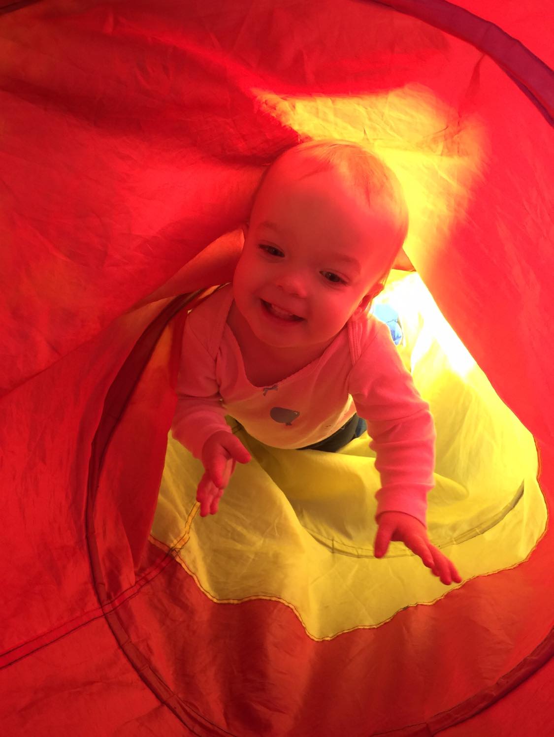 A toddler crawling inside a tent