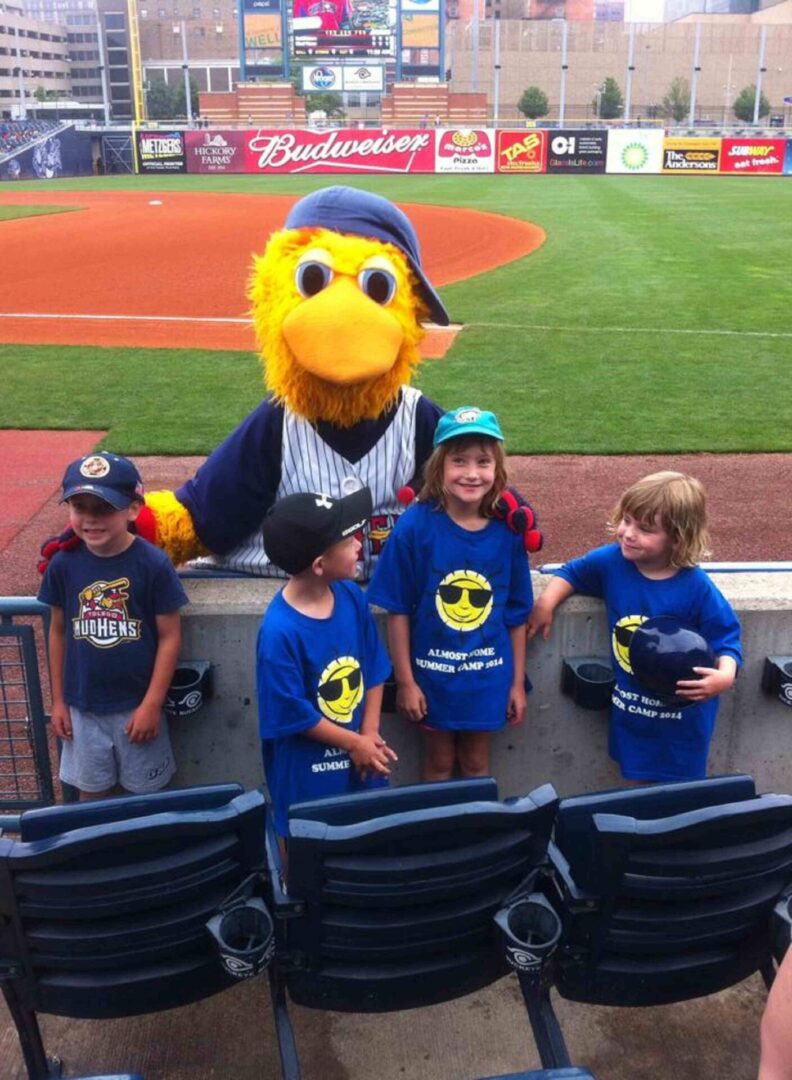 Four children standing in front of a bird mascot